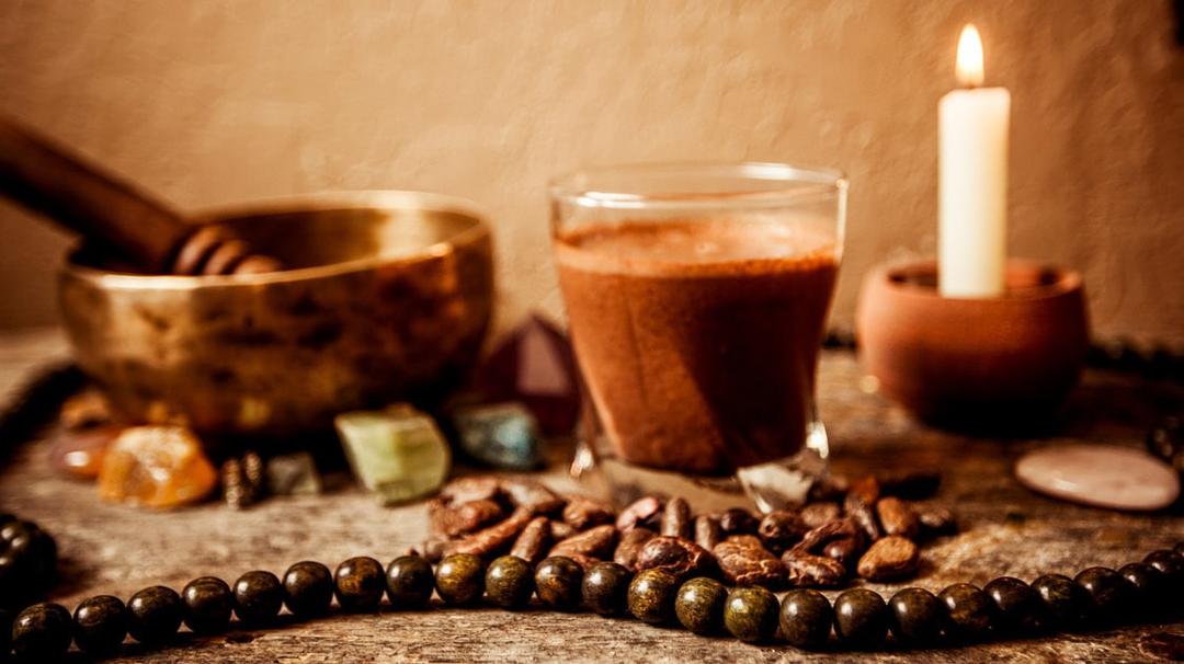 Coffee a singing bowl  a single white candle and crystals sitting on stone