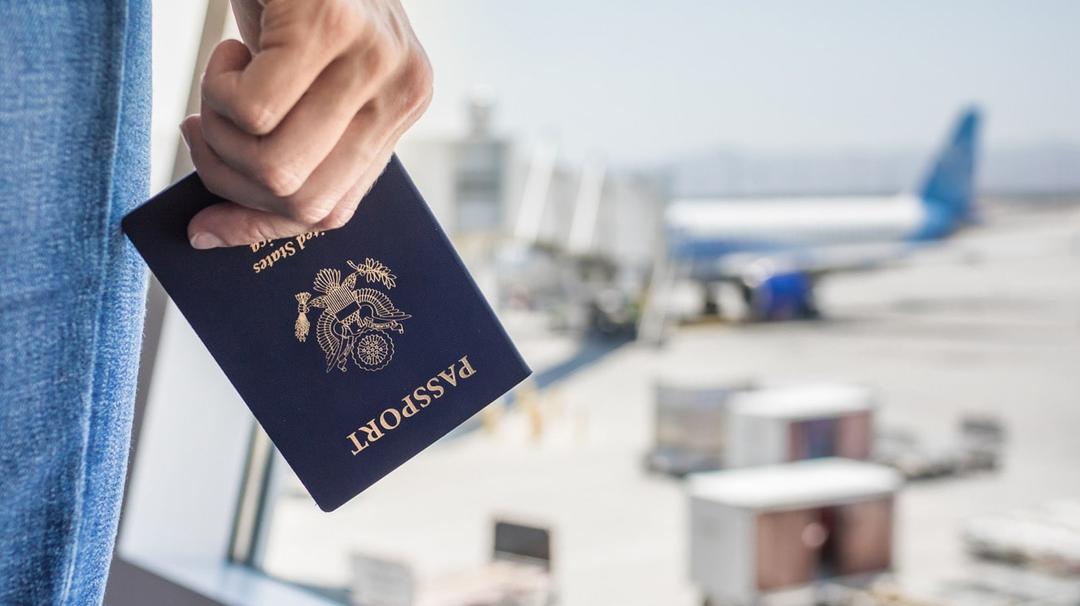 Man holding a passport standing in an airport