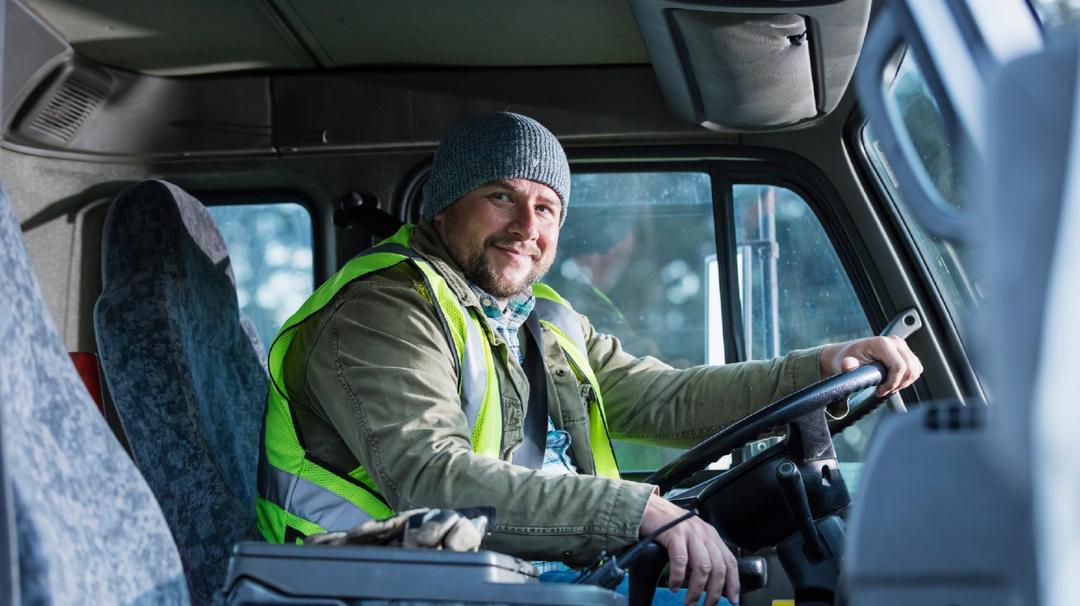 A man sitting in the driver's seat of a truck.