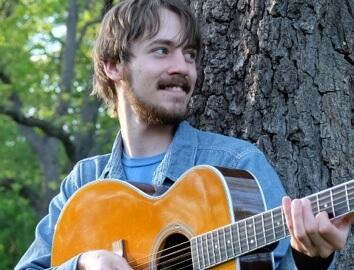 Smiling man holding acoustic guitar