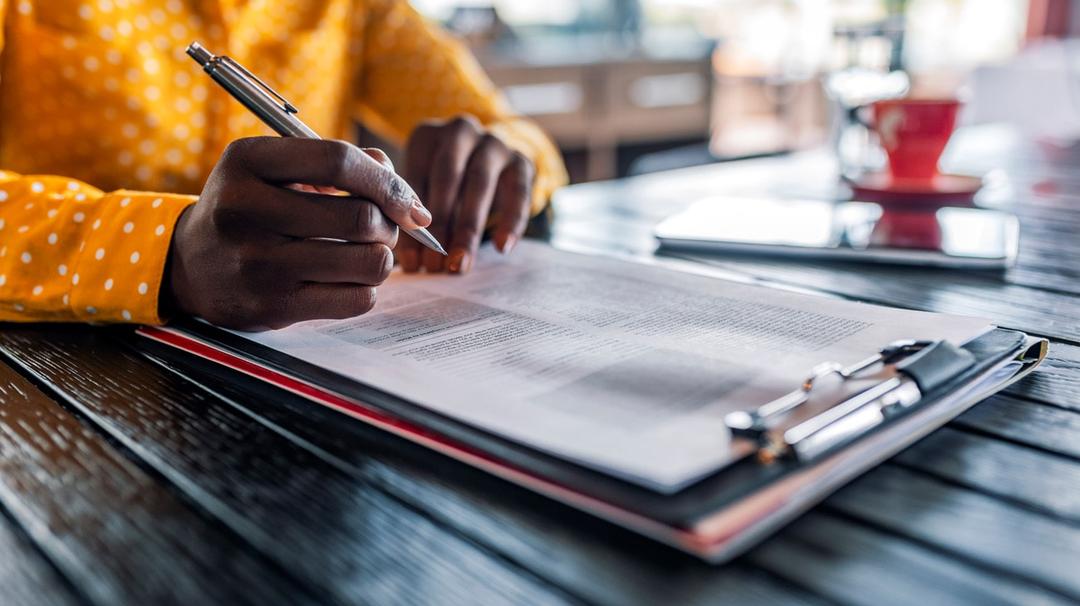 Woman reviewing EIDL information on papers sitting on a table.