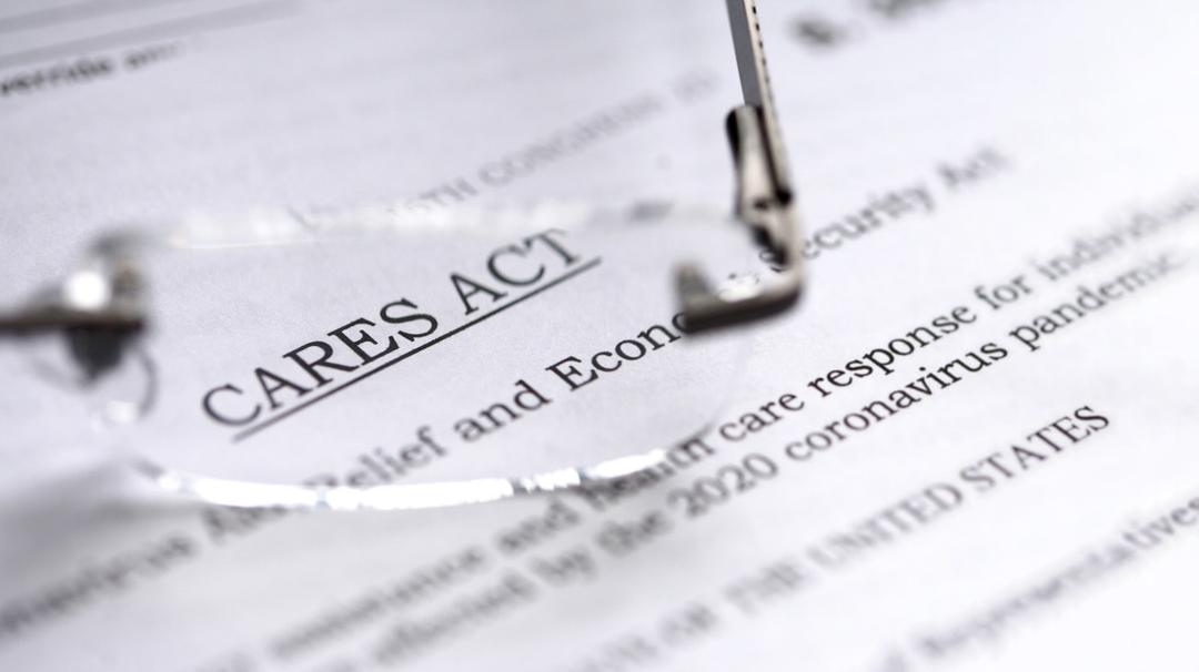 Pair of glasses sitting on top of a document with information about small business disaster loans in the CARES Act