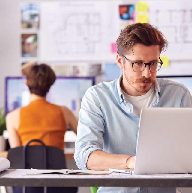 Man reviewing tax documents on laptop